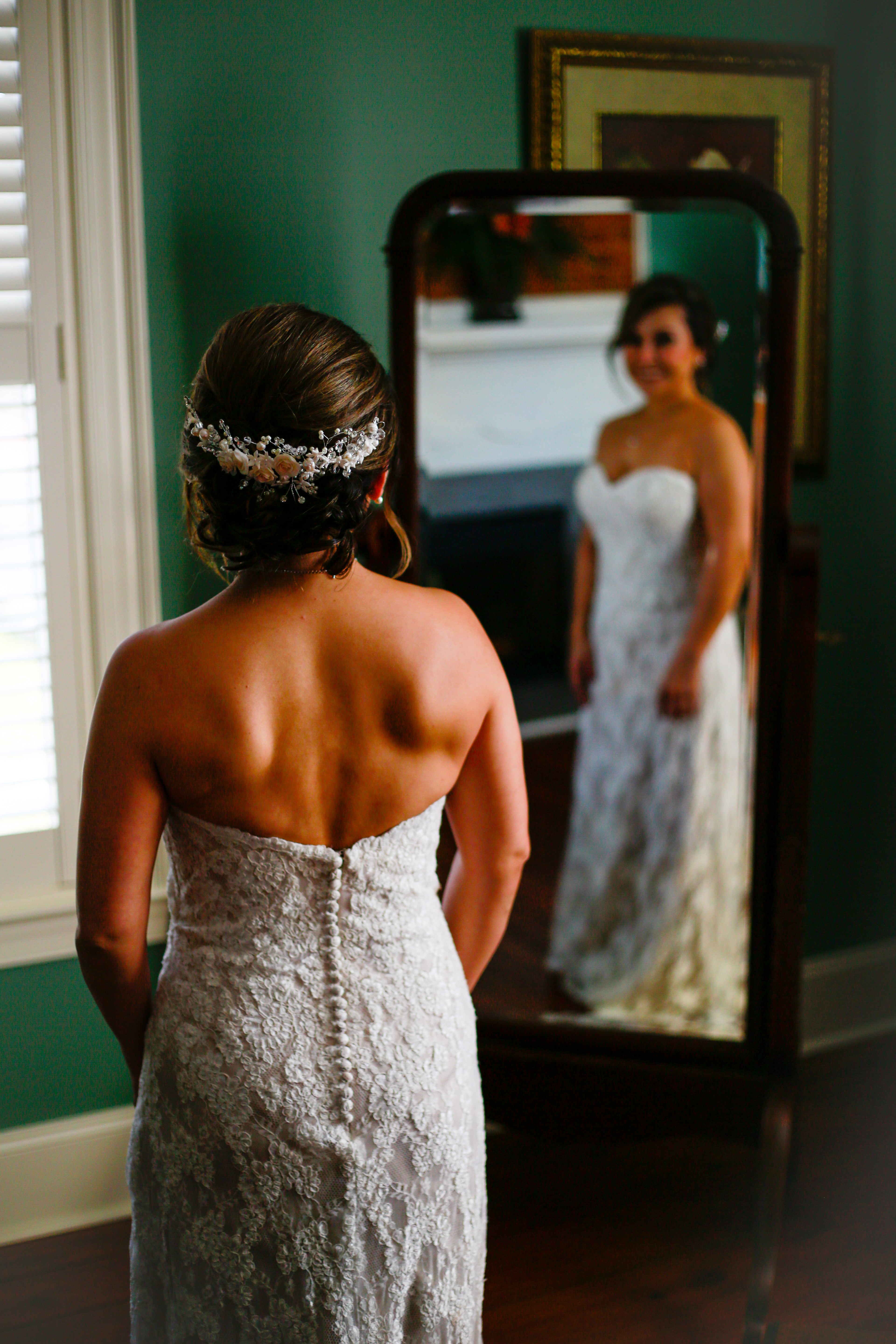 beautiful bride in antique mirror before the wedding ceremony