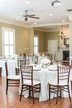 wedding reception table setup with gold chargers and white linens